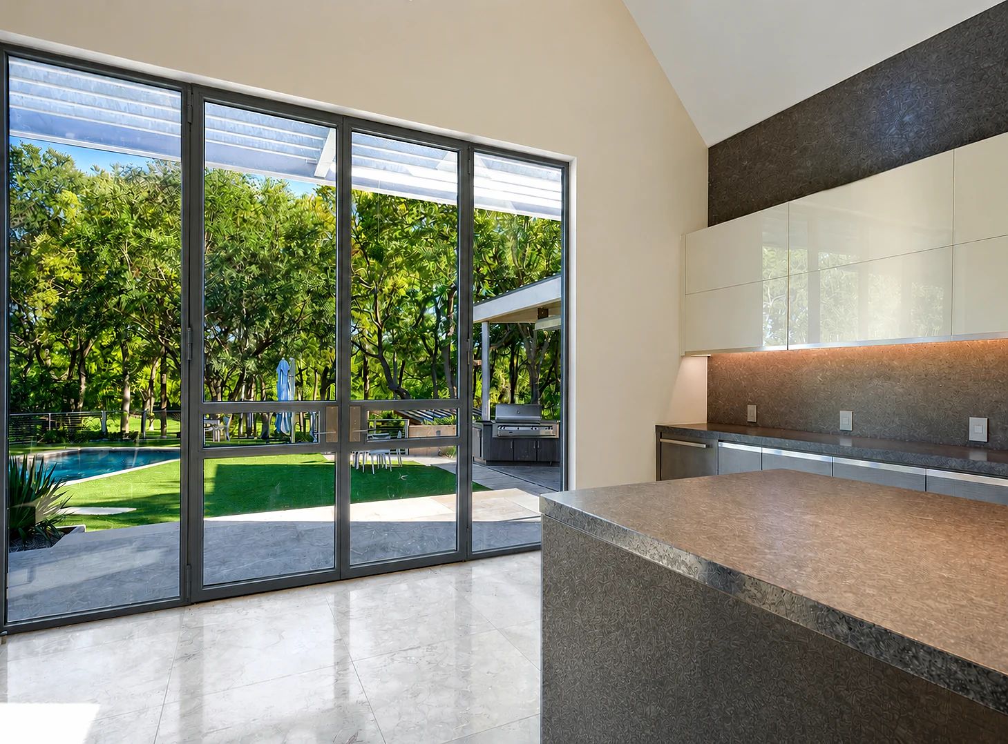 Large thermally broken steel multi-panel door assembly opening a Bent Tree residence to a pool and garden in Dallas