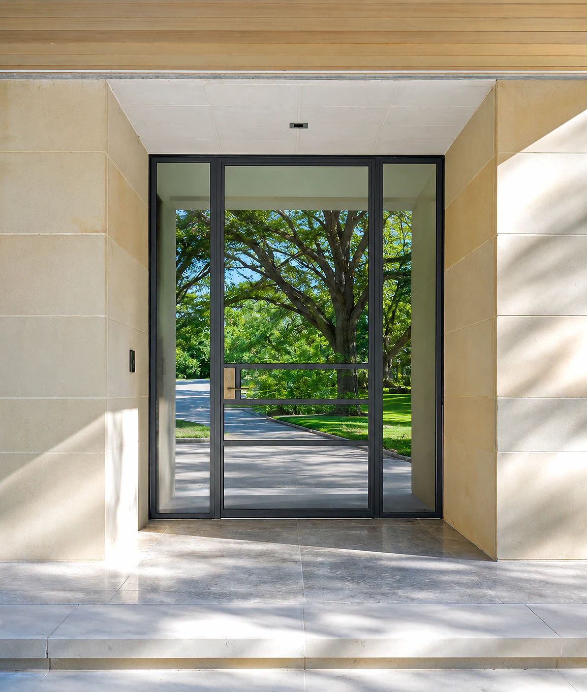 Gunmetal steel pivot entry door with sidelight at a Bent Tree residence in Dallas, Texas