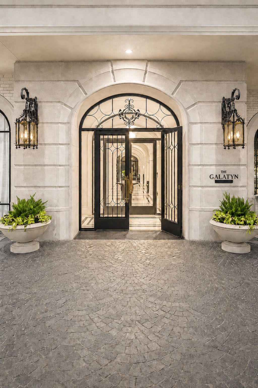 Hand-forged iron entry door beneath a stone arch