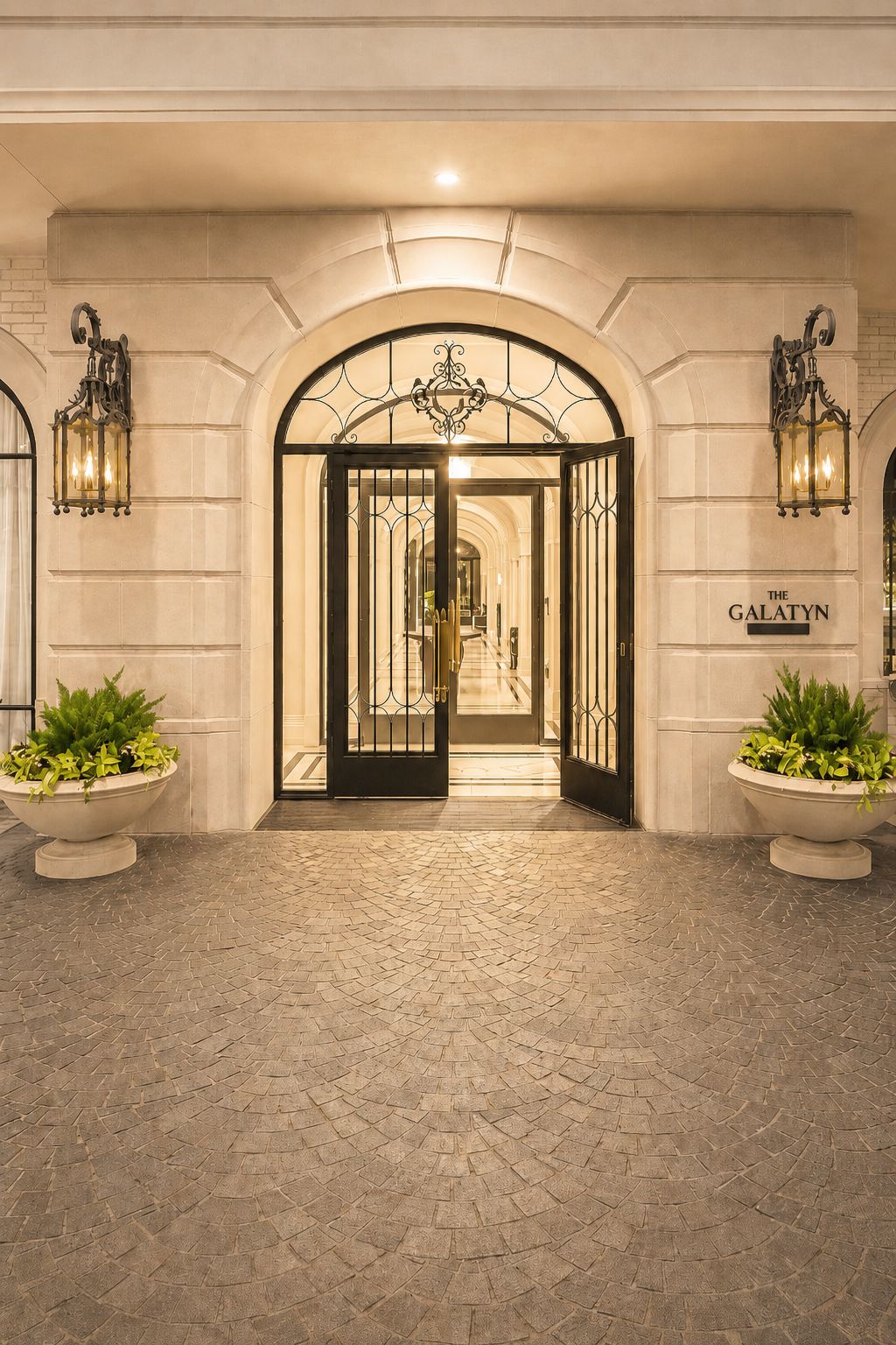 Hand-forged iron entry door beneath a stone arch at the main lobby