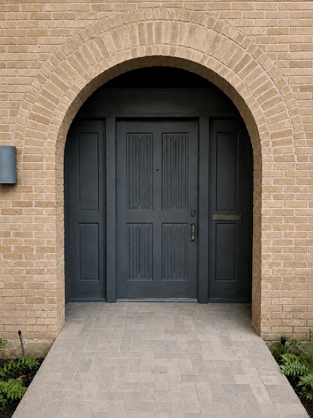 Original dark painted entry and solid sidelights beneath the semicircular brick arch before replacement