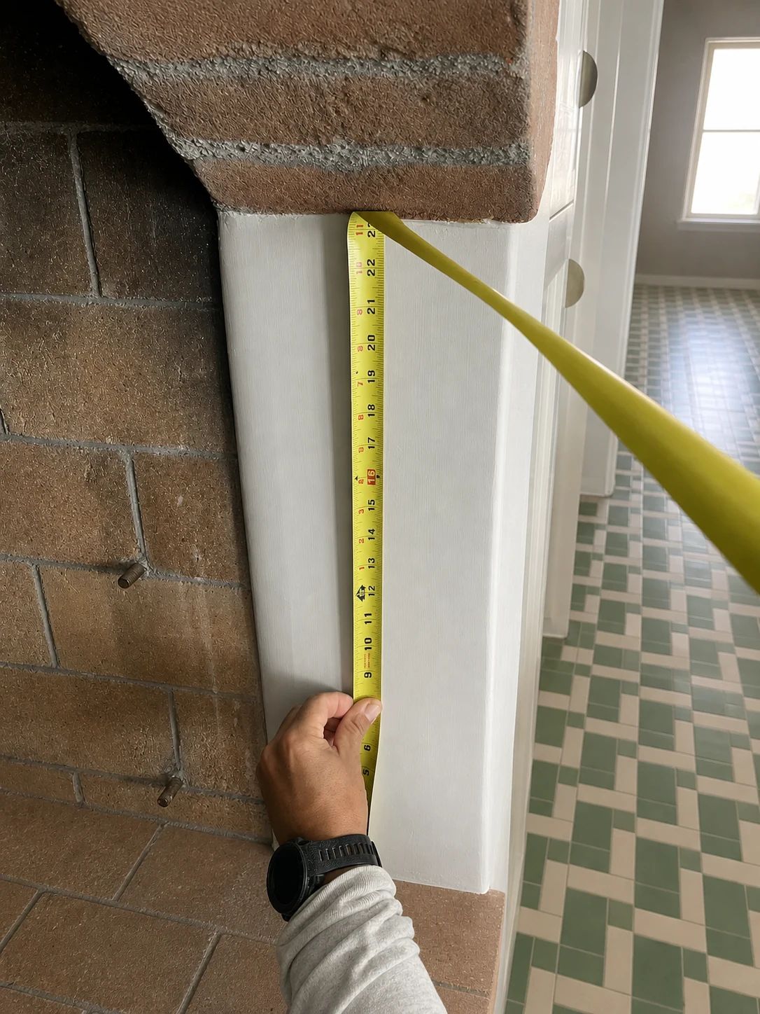 Tape and straightedge used to verify the side condition of an arched masonry fireplace opening