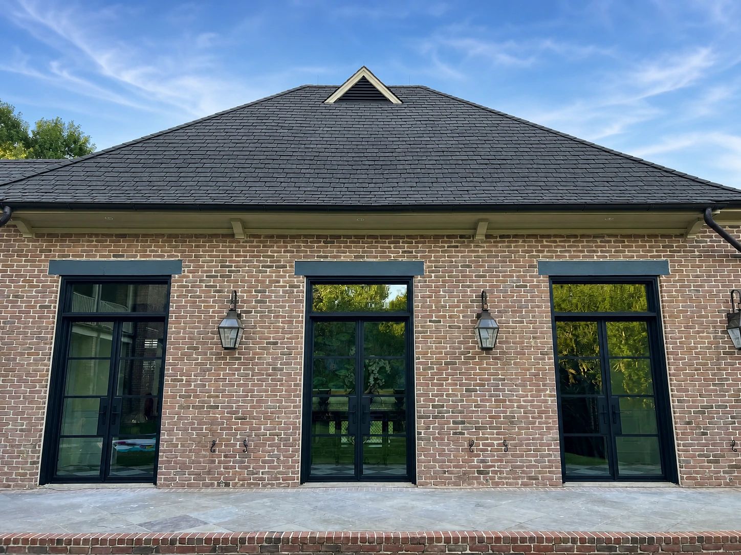 Three coordinated bronze steel-and-glass openings across the rear elevation of a Plano residence