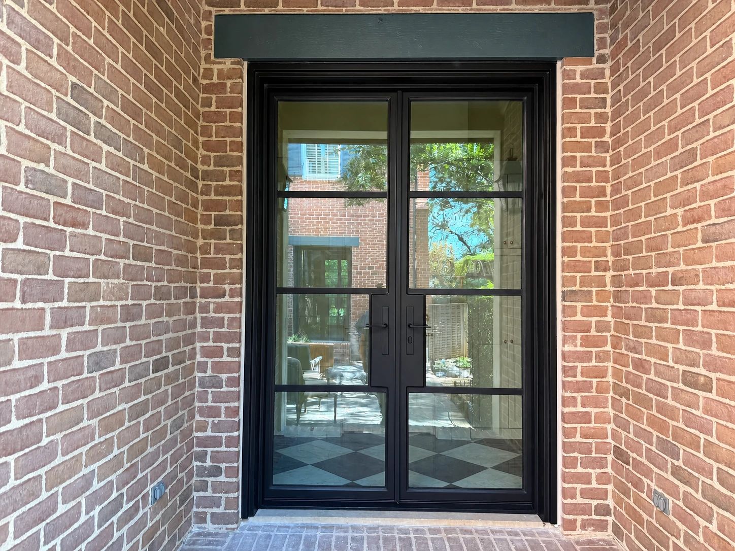 Completed bronze steel-and-glass garage-hall double door installed in 2025