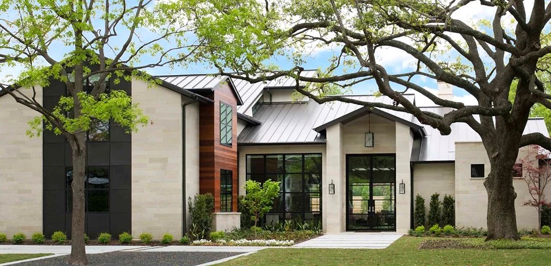 Contemporary Preston Hollow facade with custom bronze-finished steel entry door and matching wall lanterns