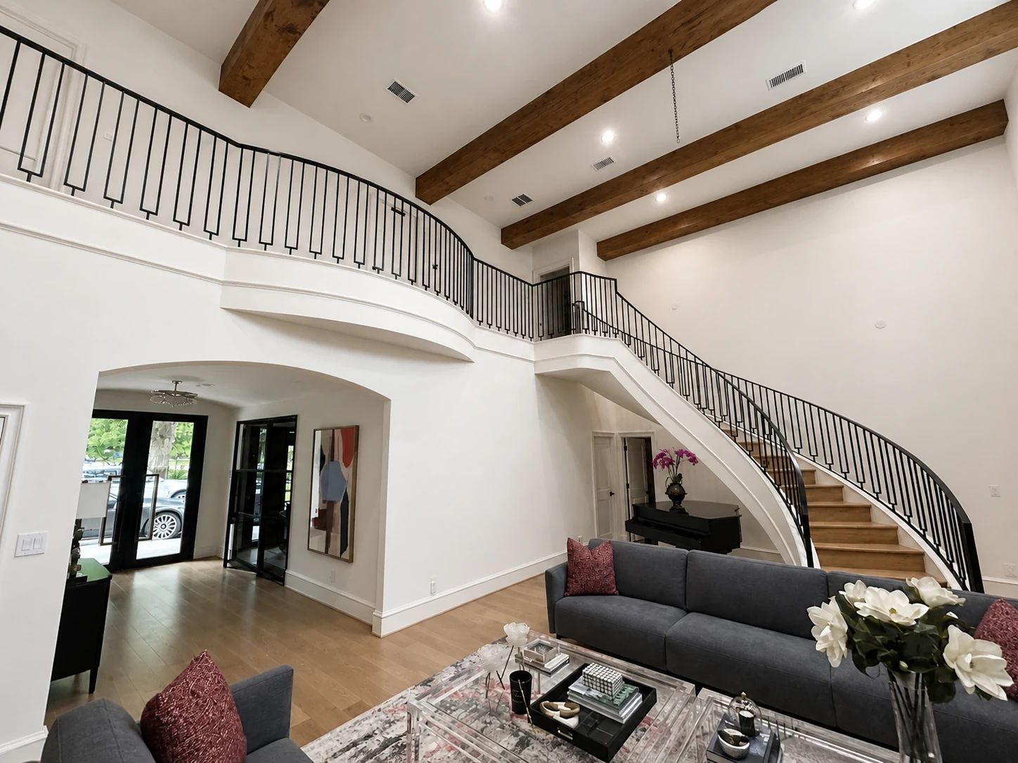 Curved black steel stair railing and coordinated steel doors in a Preston Hollow living room