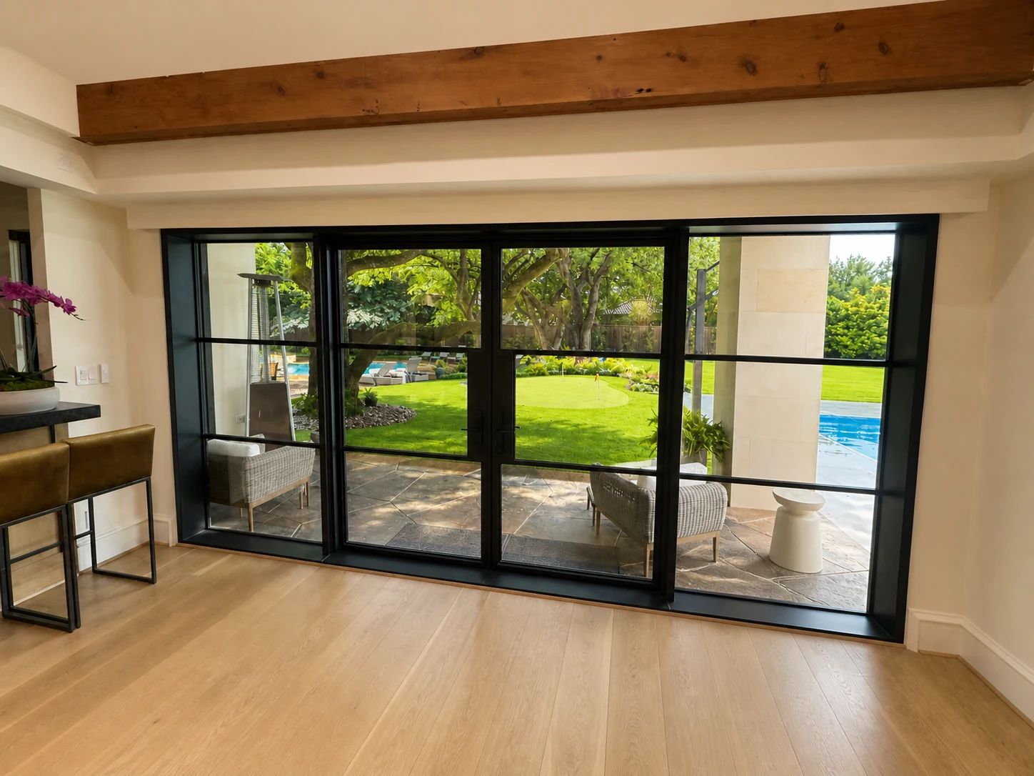 Reverse exterior view of black steel rear doors beside a Preston Hollow pool