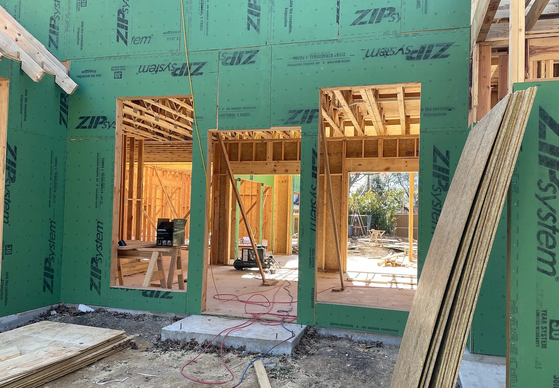 Front entry and neighboring window openings framed before installation of the Preston Hollow steel package