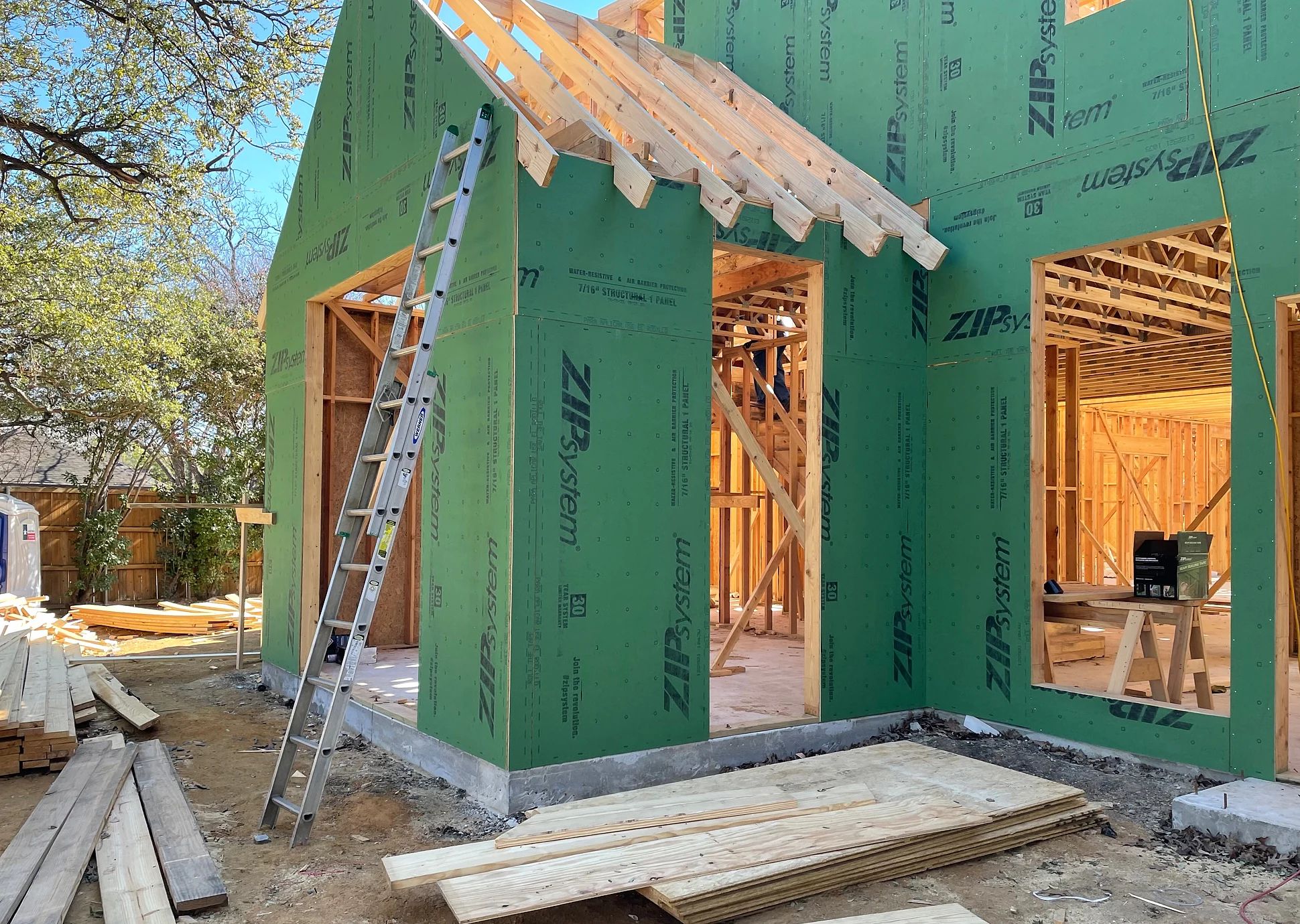 Wider construction view showing framed entry and window openings at the Preston Hollow residence