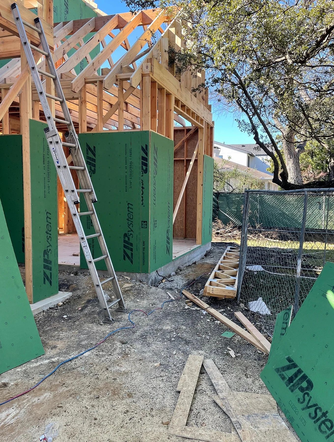 Construction framing and installation access at one arched window opening in Preston Hollow