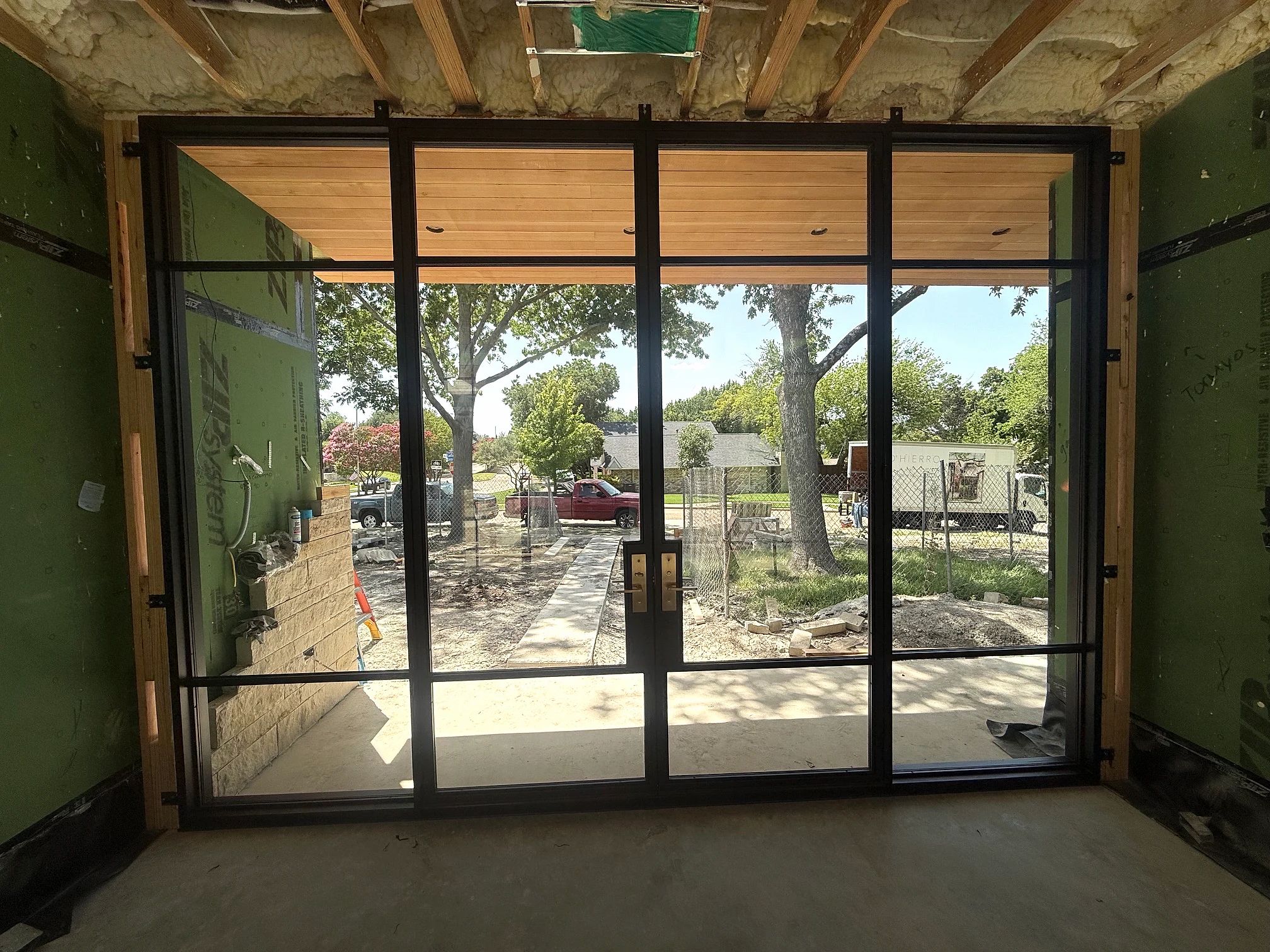 Interior construction-stage view of the complete bronze steel double entry and matching sidelites in Richardson, Texas