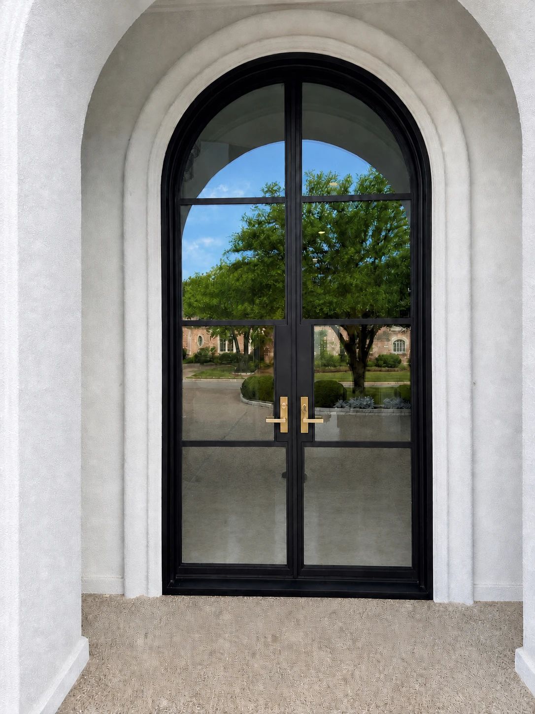 Close view of the bronze-finished arched double door and its clear glass