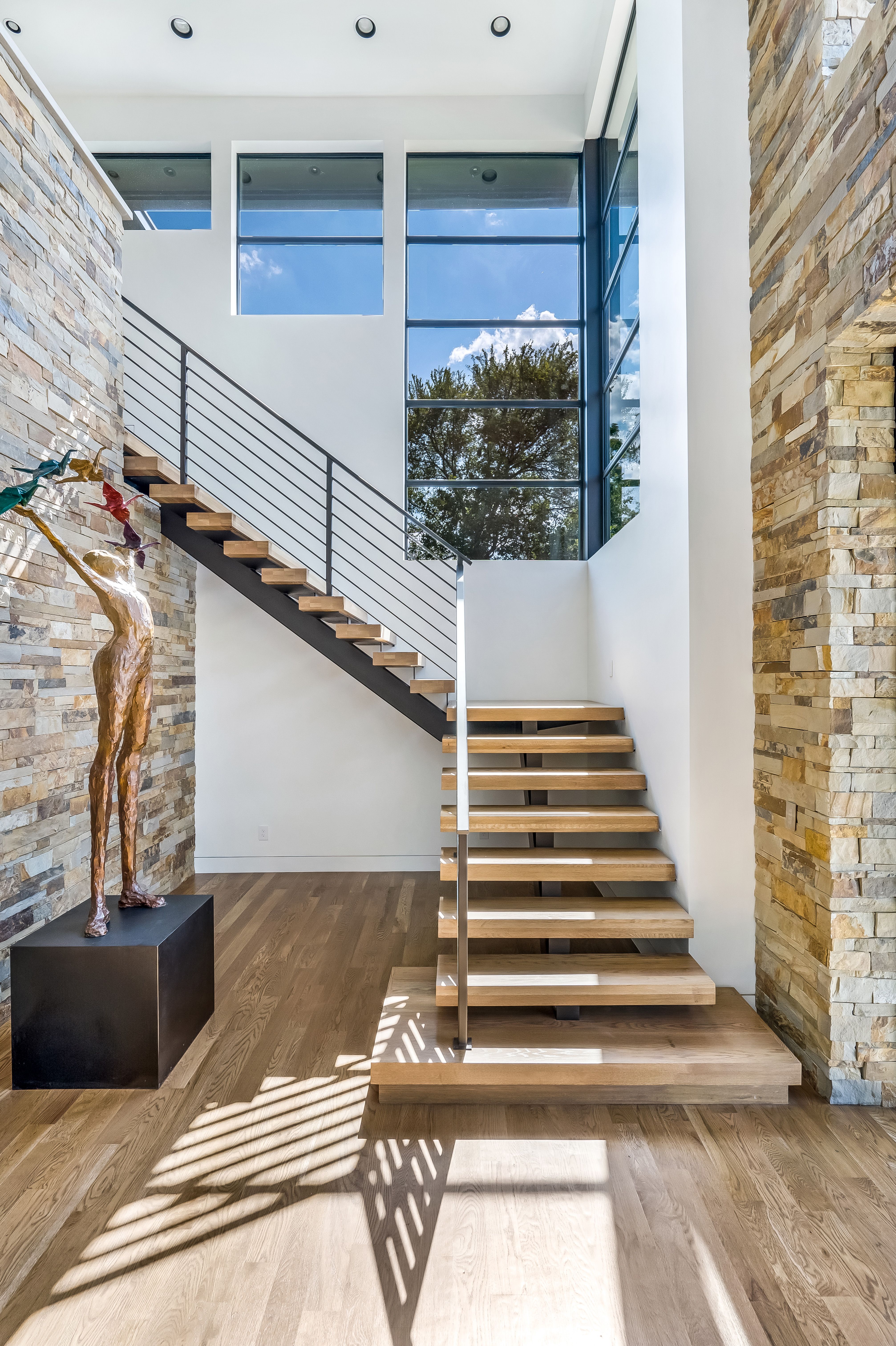 Staircase beside a full-height steel window wall