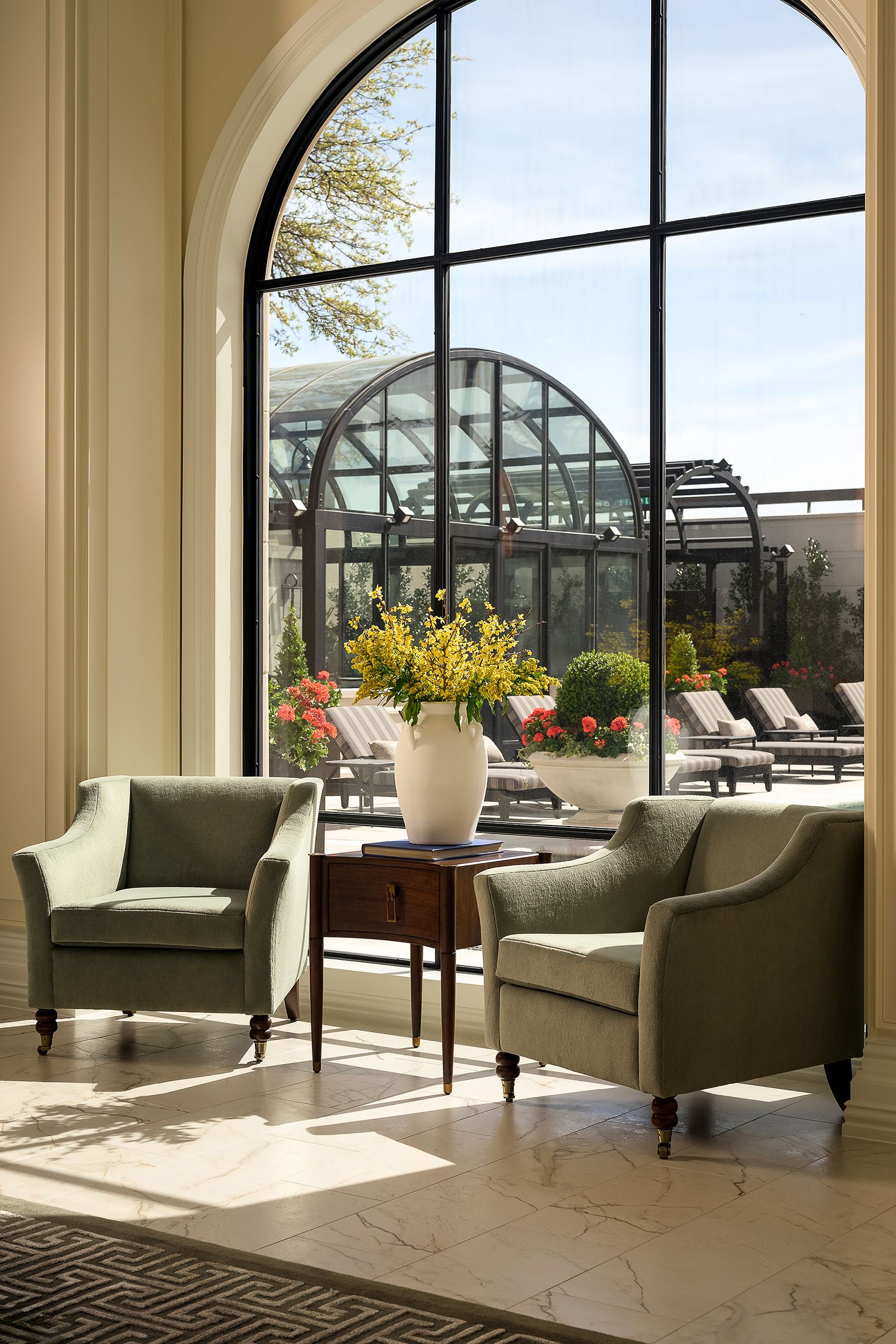 Garden room seating beneath an arched steel window wall