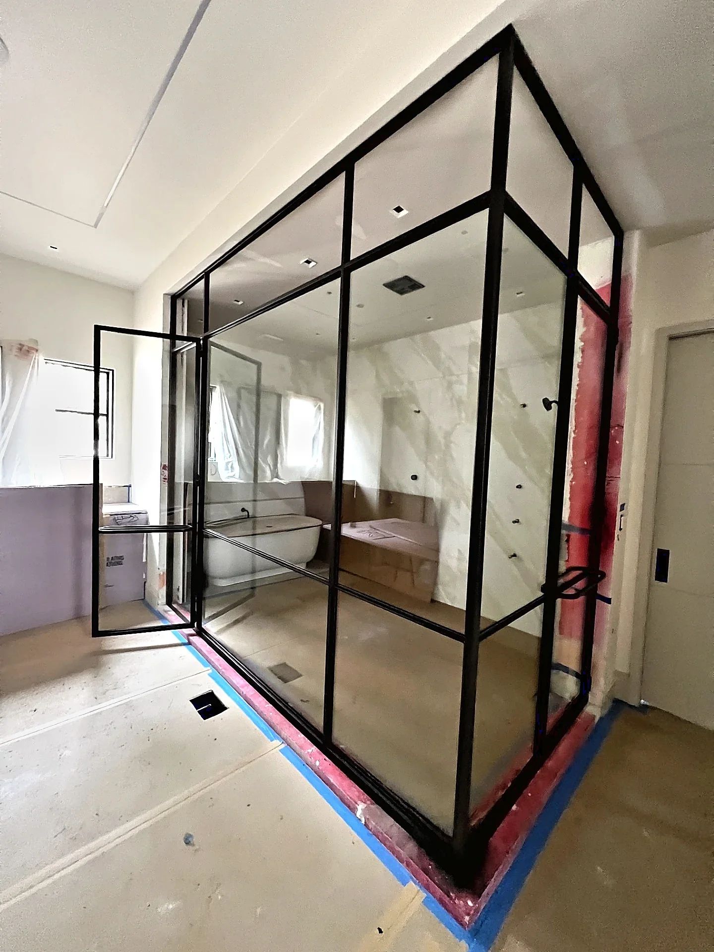 Clear tempered glass installed in a full-height corner steel shower enclosure during the Westlake project