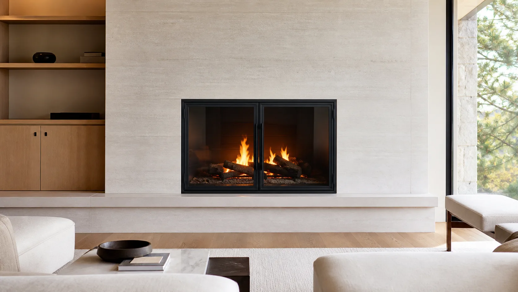 Flush matte-black fireplace doors set into a pale limestone wall