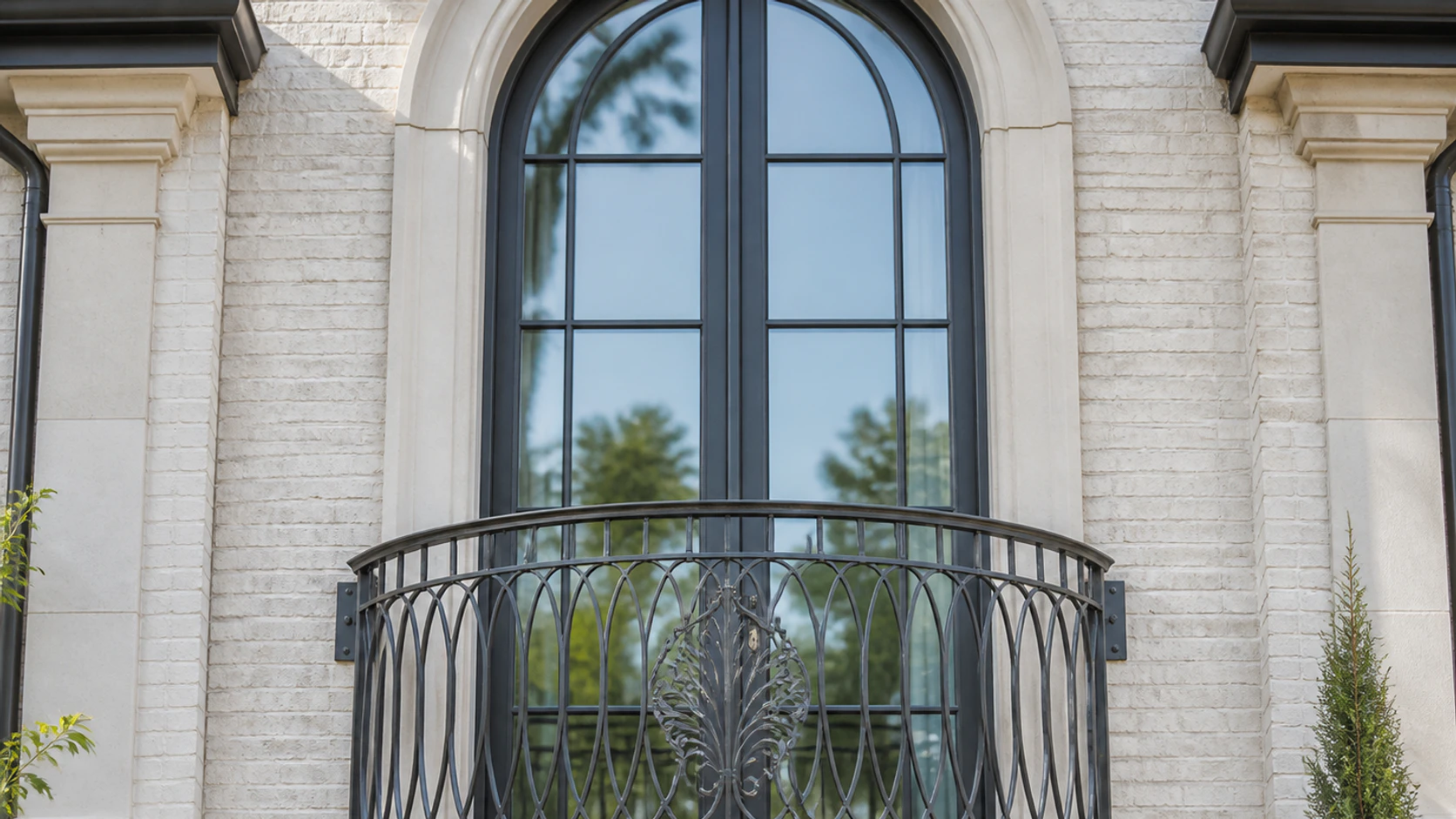 French-inspired bowed Juliet balcony with custom oval-loop ironwork